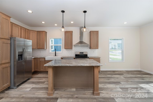 kitchen featuring sink, wall chimney exhaust hood, decorative backsplash, light hardwood / wood-style floors, and stainless steel appliances