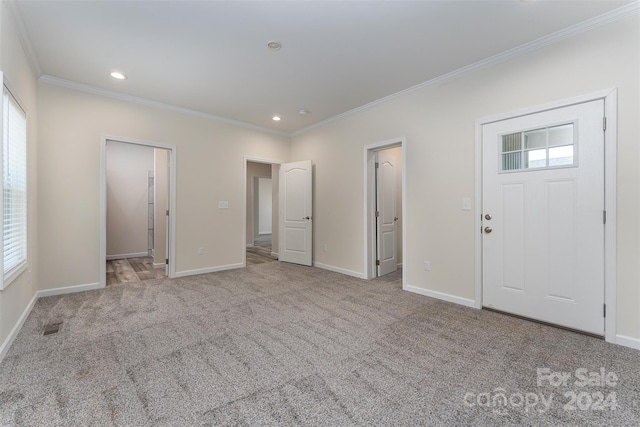 foyer entrance featuring carpet flooring and crown molding