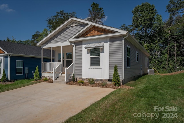 view of front of property featuring central AC unit and a front yard