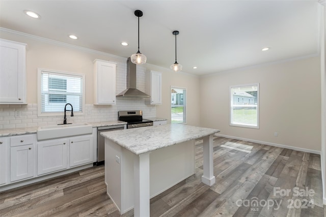 kitchen featuring sink, appliances with stainless steel finishes, wall chimney exhaust hood, and tasteful backsplash