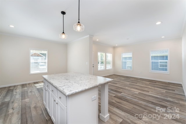 kitchen featuring white cabinetry, a center island, a breakfast bar, hardwood / wood-style flooring, and hanging light fixtures