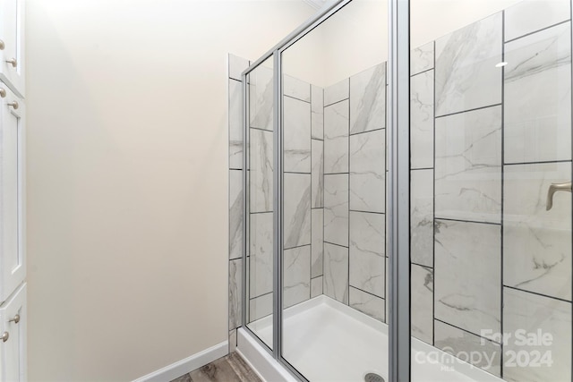 bathroom featuring wood-type flooring and walk in shower