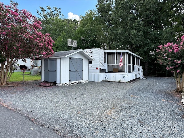 manufactured / mobile home with a sunroom and a shed