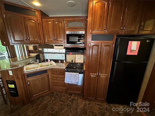 113 Hummingbird Cir, New London, NC 28127 - kitchen featuring brown cabinets, light stone counters, a sink, and black appliances