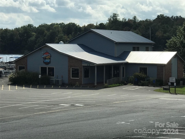 113 Hummingbird Cir, New London, NC 28127 - view of front of property featuring a view of trees, metal roof, central AC, and uncovered parking