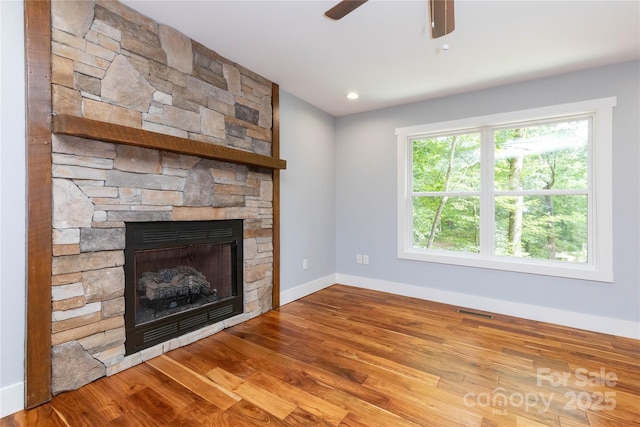 unfurnished living room featuring ceiling fan, hardwood / wood-style floors, and a fireplace