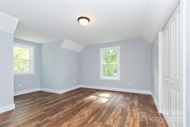 bonus room with vaulted ceiling, dark wood-type flooring, and a wealth of natural light