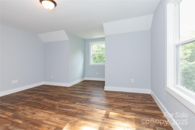 additional living space with dark wood-type flooring and a healthy amount of sunlight