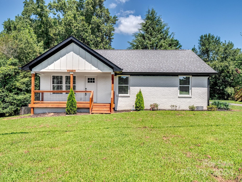 view of front of house with covered porch and a front yard