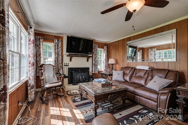 living room with a textured ceiling, wooden walls, and wood finished floors