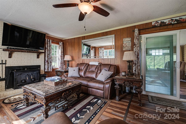 living area featuring ornamental molding, a textured ceiling, and wood finished floors