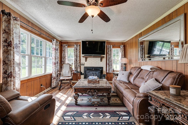 living room featuring crown molding, light wood-type flooring, and wood walls