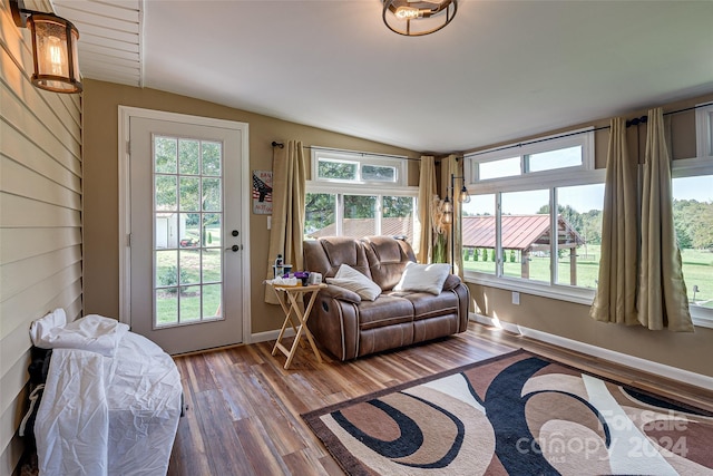 living room with vaulted ceiling, baseboards, and wood finished floors