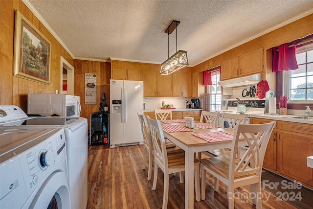 kitchen featuring pendant lighting, light countertops, washing machine and dryer, white appliances, and under cabinet range hood