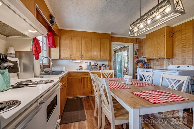 kitchen with wood finished floors, a sink, light countertops, brown cabinets, and washer / clothes dryer