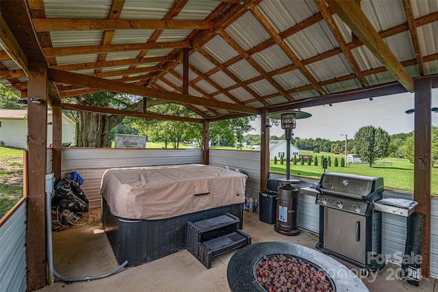 view of patio with a fire pit, a gazebo, area for grilling, and a hot tub