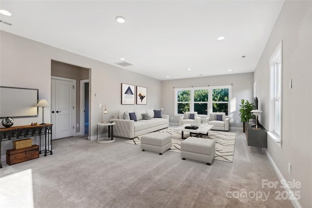 living room featuring light carpet, visible vents, baseboards, and recessed lighting