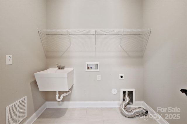 clothes washing area featuring hookup for a washing machine, visible vents, hookup for an electric dryer, laundry area, and baseboards