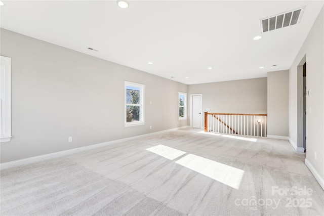 spare room featuring light carpet, baseboards, visible vents, and recessed lighting