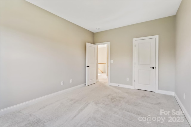 unfurnished bedroom with light carpet and baseboards