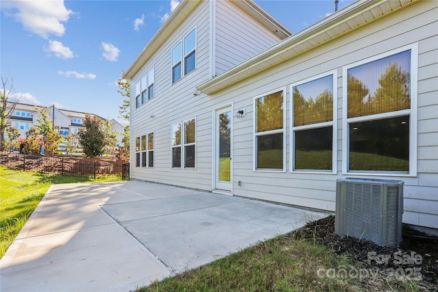 rear view of house featuring a patio, central AC unit, and fence