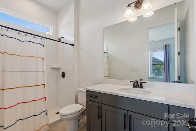 bathroom featuring curtained shower, vanity, and toilet