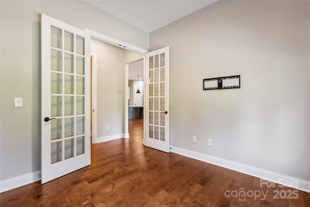 unfurnished room featuring french doors, baseboards, and dark wood-style flooring