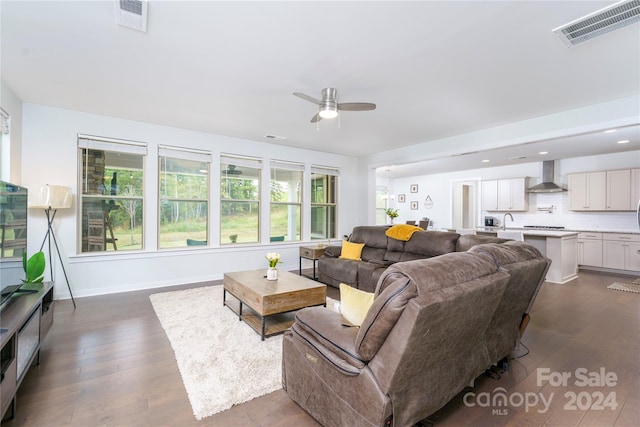 living room featuring ceiling fan and dark wood-type flooring