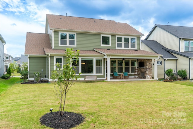 rear view of house featuring a lawn and a patio area