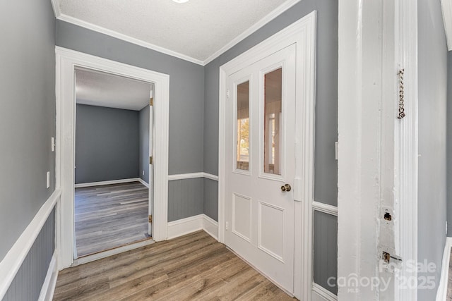 interior space featuring ornamental molding, a textured ceiling, and hardwood / wood-style flooring