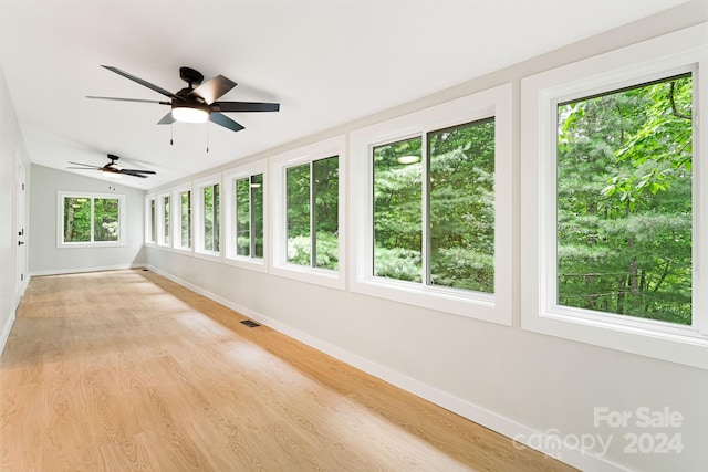 unfurnished sunroom featuring ceiling fan