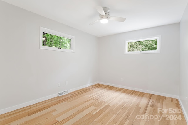 spare room with ceiling fan, plenty of natural light, and light hardwood / wood-style floors