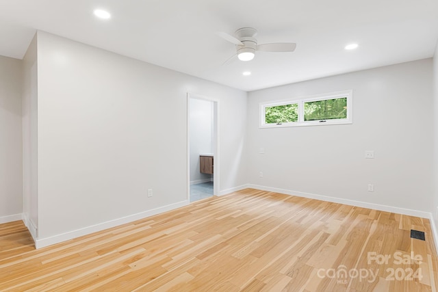 empty room with ceiling fan and light hardwood / wood-style flooring