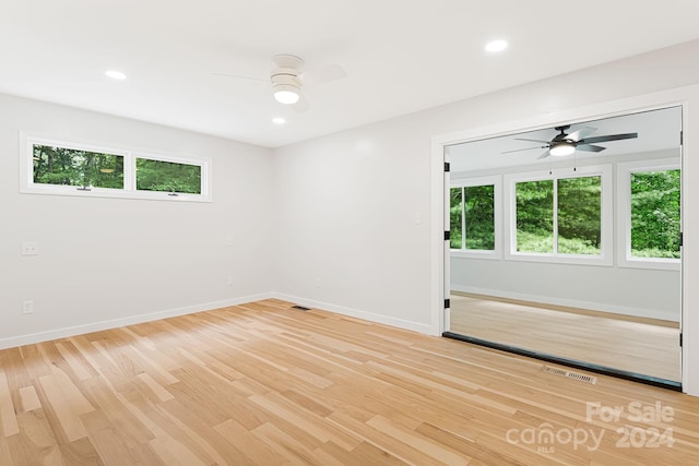 spare room featuring light wood-type flooring, ceiling fan, and a healthy amount of sunlight