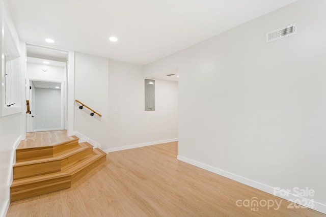 staircase with hardwood / wood-style flooring and electric panel