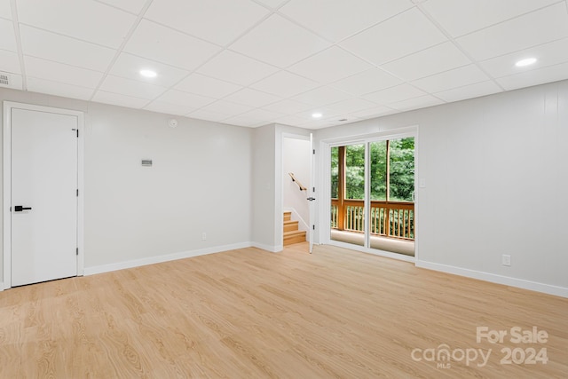 empty room featuring light hardwood / wood-style floors and a paneled ceiling