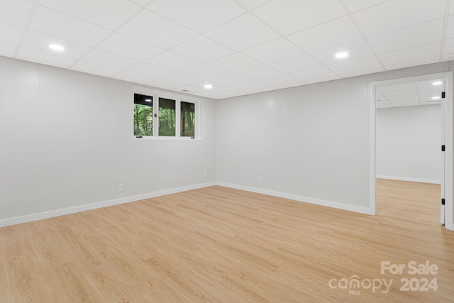 interior space with a drop ceiling and light hardwood / wood-style flooring