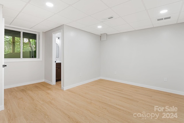 empty room featuring light hardwood / wood-style floors and a paneled ceiling