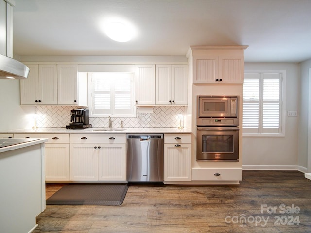 kitchen with white cabinetry, tasteful backsplash, sink, dark hardwood / wood-style floors, and appliances with stainless steel finishes