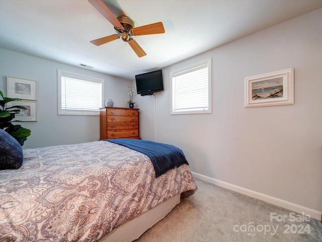 bedroom with multiple windows, ceiling fan, and carpet flooring