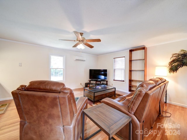 living room with a wall mounted AC, ornamental molding, ceiling fan, and light hardwood / wood-style floors