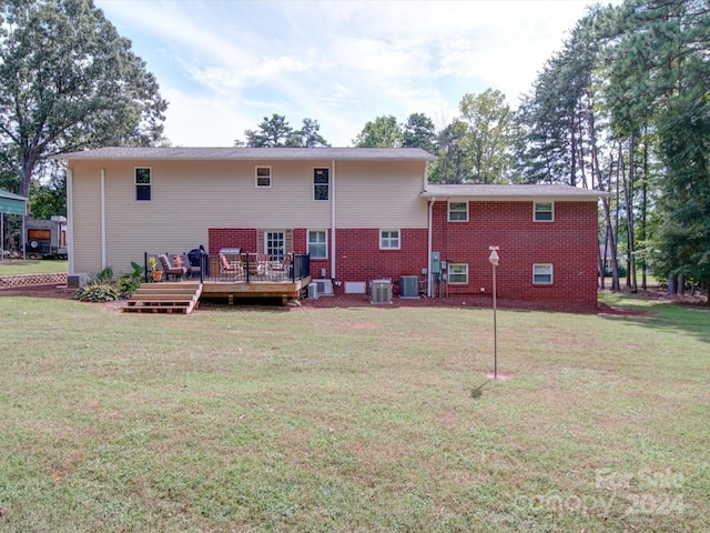 back of property with a lawn, a deck, and cooling unit