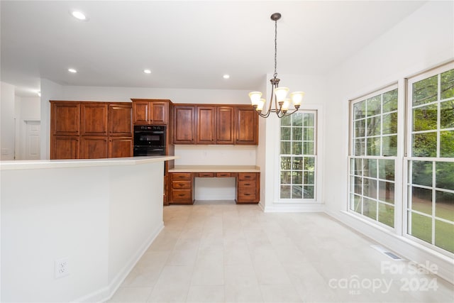 kitchen with decorative light fixtures, double oven, a chandelier, and light tile patterned floors