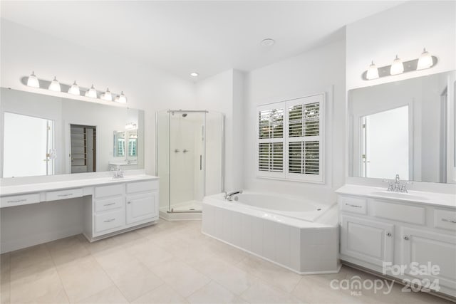 bathroom with a healthy amount of sunlight, shower with separate bathtub, vanity, and tile patterned floors