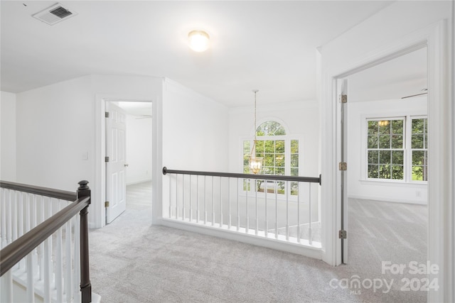 hall with light colored carpet and ornamental molding