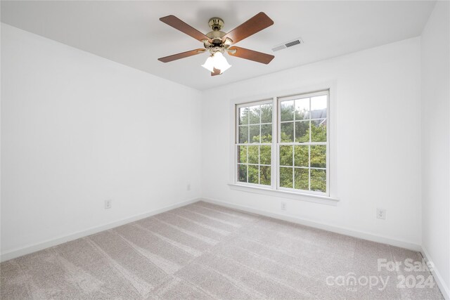 carpeted spare room featuring ceiling fan