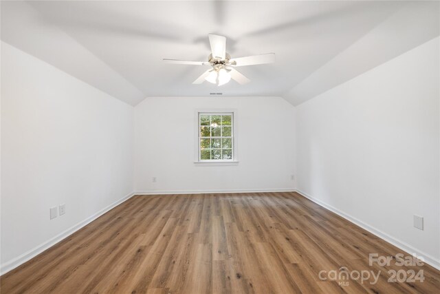 spare room with ceiling fan, vaulted ceiling, and hardwood / wood-style floors