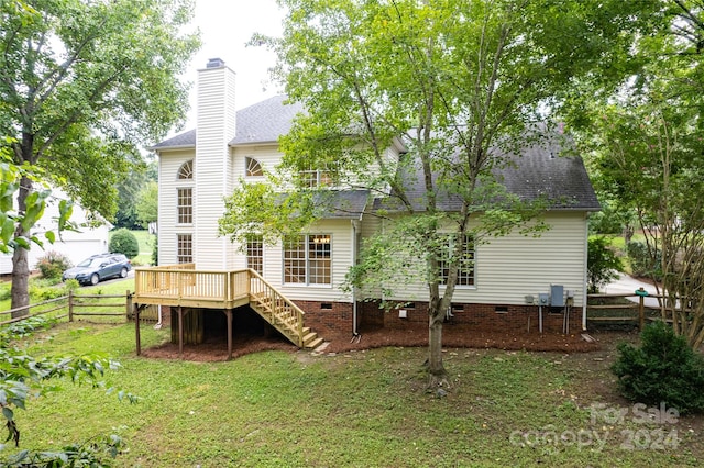 rear view of house with a wooden deck and a yard