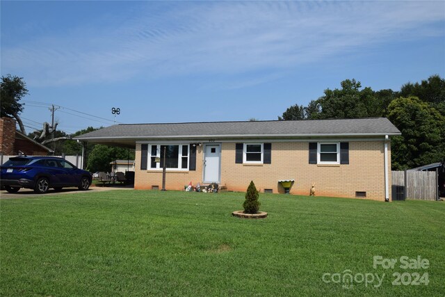 single story home featuring a front lawn, central AC, crawl space, an attached carport, and brick siding