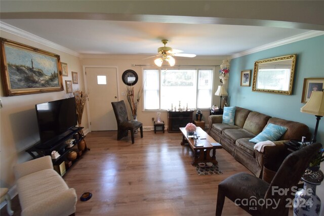 living room featuring ceiling fan, crown molding, and wood-type flooring